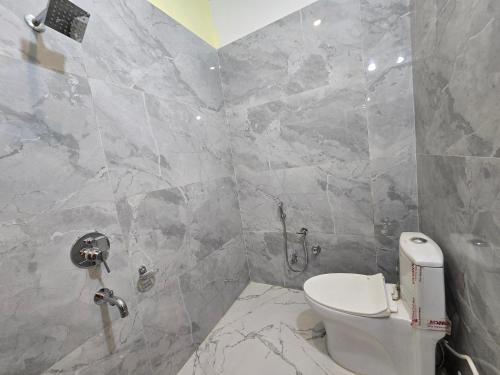 BegusaraiSAROJINI GARDEN HOTEL & RESTAURANT的浴室设有白色卫生间和大理石墙壁。