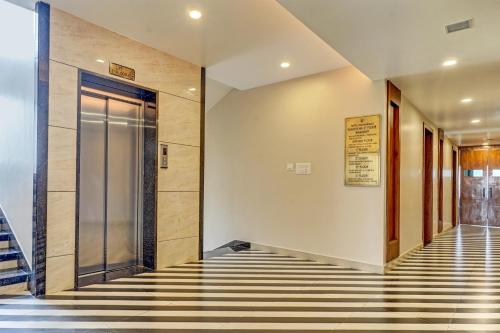 博帕尔Palette - Hotel Ocean Breeze的电梯大厅设有玻璃门和条纹地板