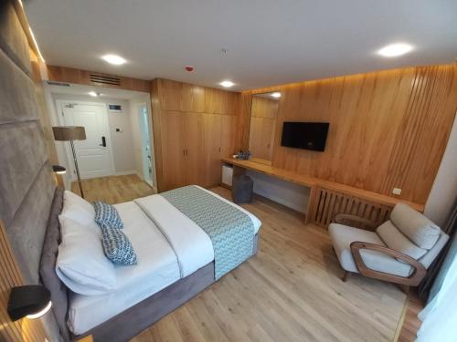 巴统Hotel Black Sea的一间卧室配有一张床、一张沙发和一台电视。