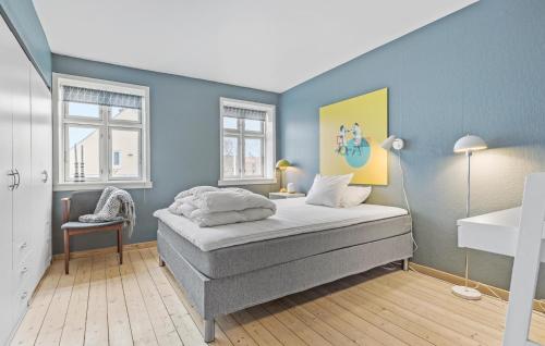 Løgstør4 Bedroom Cozy Home In Lgstr的一间卧室设有一张床和蓝色的墙壁