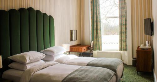 伦敦The Columbia的酒店客房设有两张床和绿色的墙壁。