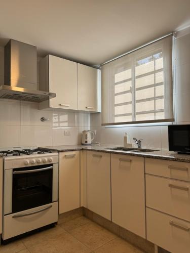 门多萨DEPARTAMENTO Céntrico MENDOZA的厨房配有白色橱柜和炉灶烤箱。
