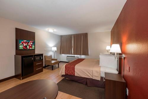 波基普西波基普西红屋顶客栈的酒店客房配有一张床铺和一张桌子。