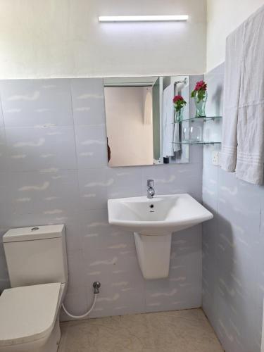 卡尔库达Baden Beach的白色的浴室设有水槽和卫生间。