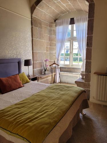 Saint-Quay-Perros格昂庄园酒店的一间卧室设有一张大床和一个窗户。