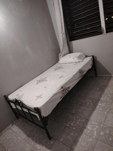 巴拿马城Fresco apto a 10 min del aeropuerto y la ciudad的一张小床,位于客房的角落