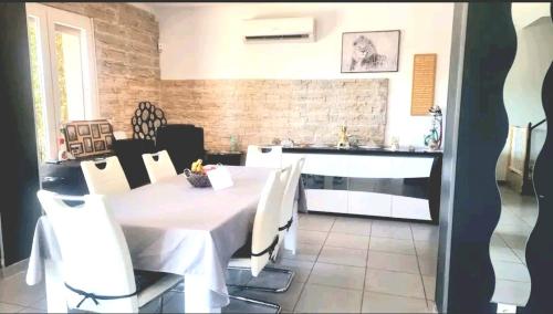 罗尼亚克Agréable Villa 8pers avec vue mer LOGEMENT ENTIER的一间配备有白色桌椅的用餐室