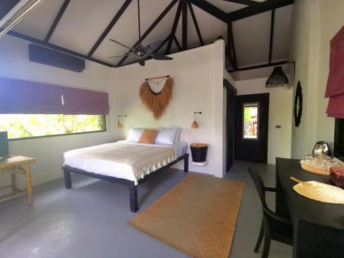 苏梅岛Jade cottages的一间卧室设有一张床、一个用餐区和一张桌子