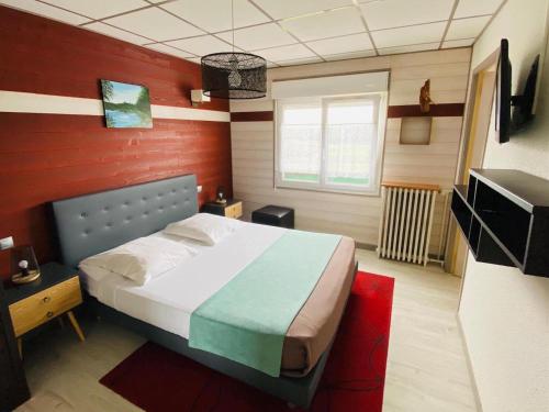格尔蒙特维勒阿瓦尔康博图小屋公寓酒店的一间卧室设有一张床和红色的墙壁