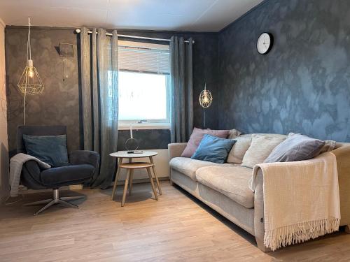 拉克塞尔夫Fin sentral leilighet i Lakselv!的客厅配有沙发和椅子