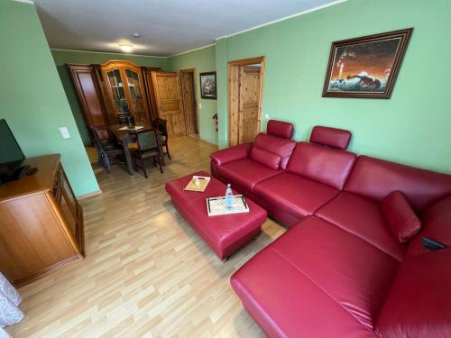 科尔平塞加尼瑟斯霍斯恩酒店的客厅配有红色的沙发和桌子