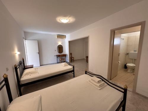 卡里利梅内斯Sfinias Apartments的带浴室的客房内的两张床