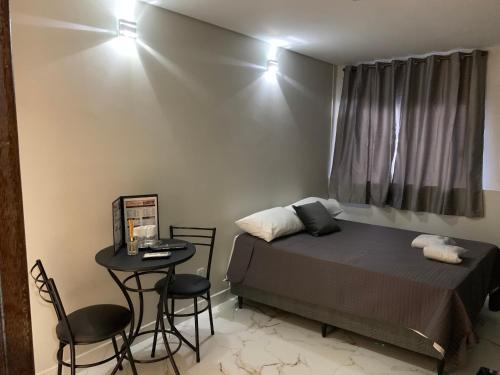 巴西利亚Hotel Oásis的卧室配有一张床和一张桌子及椅子