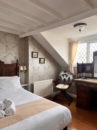 兰迪德诺玫瑰托尔酒店的一间卧室配有一张床、一张桌子和一把椅子