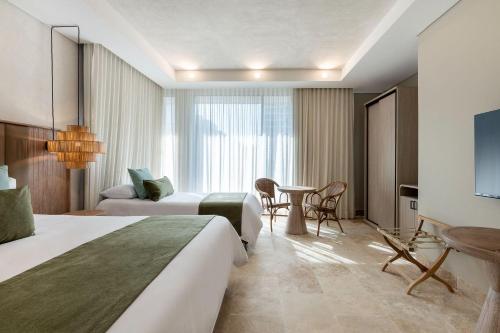 卡塔赫纳Oz Hotel Cartagena的酒店客房设有两张床和一张桌子。