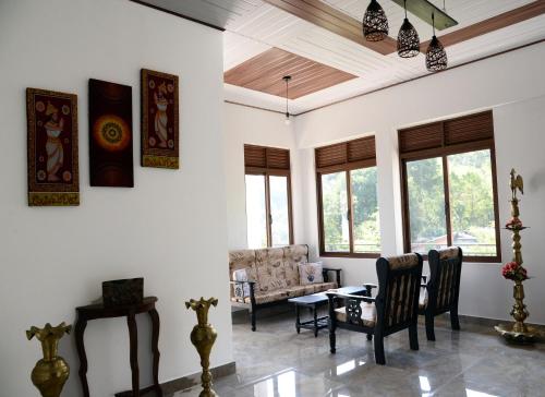 康提Green Bird Villas的客厅配有桌椅和窗户。