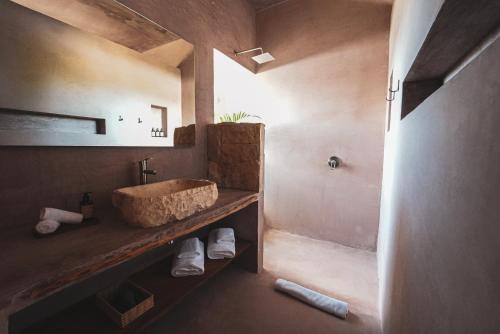 埃尔库约Nikau Hotel El Cuyo - Adults Only的一间带石质水槽和淋浴的浴室