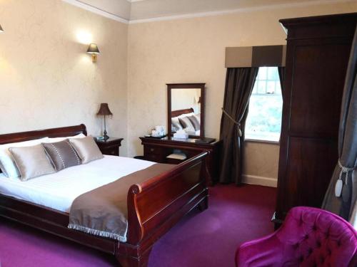 阿洛厄OYO Dunmar House Hotel的一间卧室配有一张床、镜子和椅子