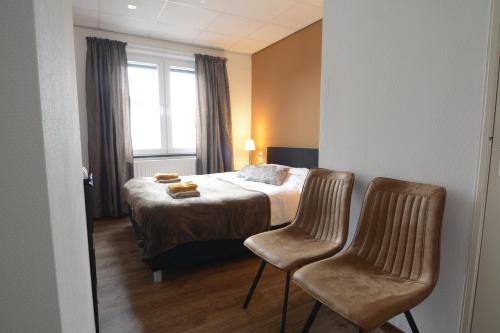 斯欣奥普赫尔Bed & Breakfast Hotel Het Gerendal的酒店客房,配有一张床和两把椅子