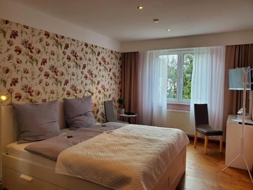 瓦尔德布勒尔Privatpension Waldbröl的一间卧室配有一张带花卉壁纸的床