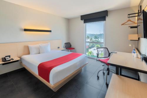 帕拉伊索City Express by Marriott Paraiso的配有一张床、一张书桌和一扇窗户的酒店客房