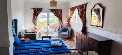 拉拉塔可库斯特Tiki House Marrakech chez Paul的客厅配有蓝色的床和镜子