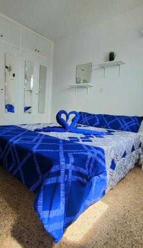 马斯帕洛马斯Sunny Room in Habitat的卧室的床上的蓝色被子