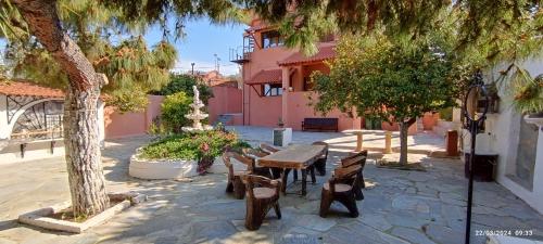 爱琴娜岛Aegina town, summer house的庭院内带桌椅的庭院。