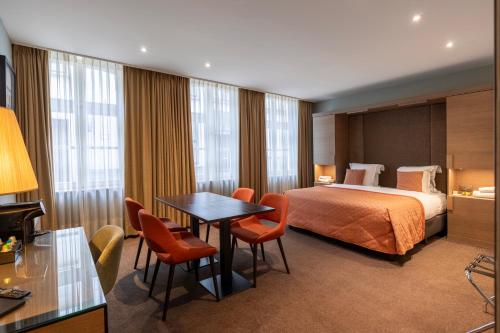 布鲁日阿拉贡酒店的酒店客房带一张床、一张桌子和椅子