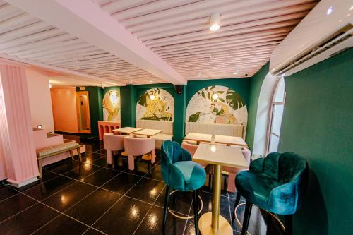 卡塔赫纳Sublime Hotel Boutique Cartagena的餐厅拥有绿色的墙壁和桌椅