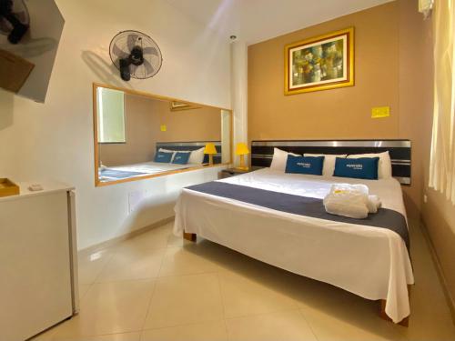 皮乌拉Suite Apart Miraflores的一间卧室配有一张大床和镜子