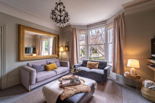 切尔滕纳姆Victorian Townhouse 5 bedrooms Cheltenham的客厅配有两张沙发和一面镜子