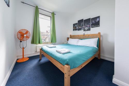 伦敦Pax Lodge的一间卧室配有一张带风扇和窗户的床。