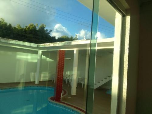 拉巴拉德纳圣米格尔Pousada Cantinho da Barra的透过玻璃窗可欣赏到游泳池的景色