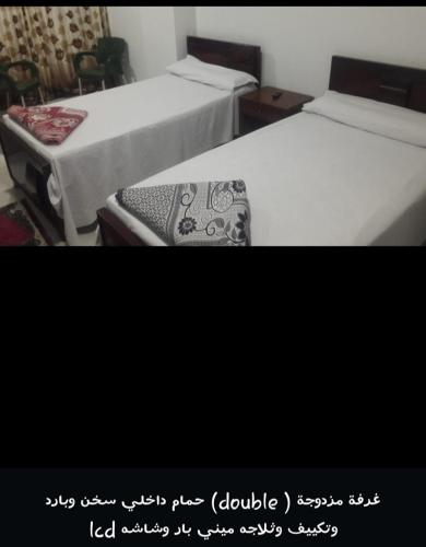 Al Khārijahفندق المهندس的两张睡床彼此相邻,位于一个房间里