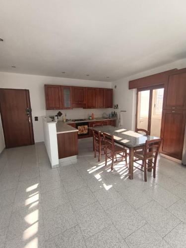 雷焦卡拉布里亚Vista Monte Retreat的厨房配有桌子、木制橱柜和桌椅