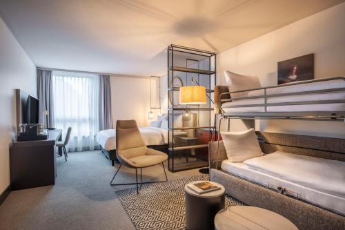 纽伦堡Scandic Nürnberg Central的酒店客房设有两张双层床和一张书桌。