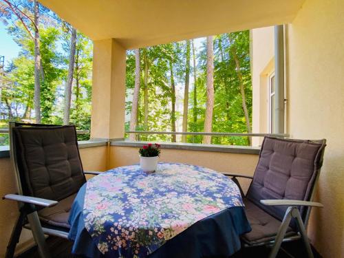 赛巴特班森Neue Villa Ernst - Ferienwohnung 3的阳台配有桌子和两把椅子,设有窗户。