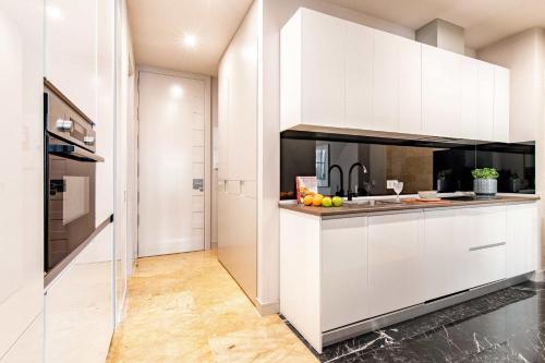 伦敦Premium Belgravia Harrods Apartment的厨房配有白色橱柜和水果台