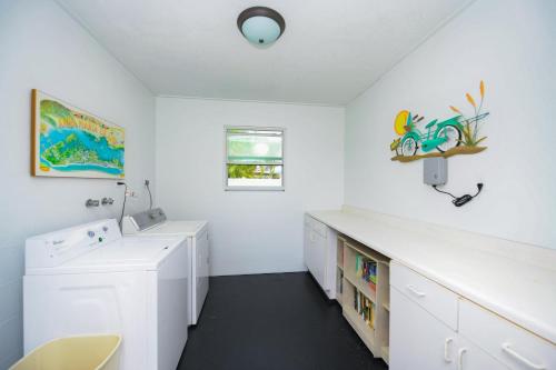 安娜玛丽亚Southern Breeze 4的白色的客房配有书桌和洗衣机。