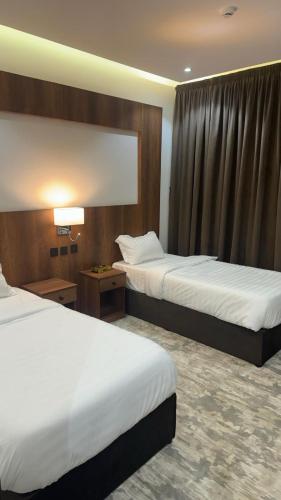 Sīdī Ḩamzahدرة الشرق للشقق المخدومة的酒店客房设有两张床和窗户。