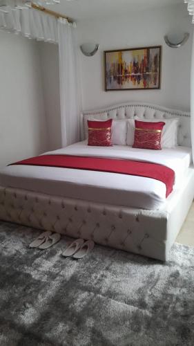 基苏木Diana executive residents的一间卧室配有一张带红色枕头的大床