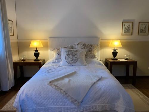 LangschlagItha’s secret escape的一间卧室配有一张带两盏灯的大型白色床。