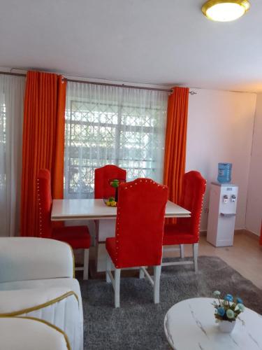 基苏木Diana executive residents的一间用餐室,配有红色的椅子和桌子