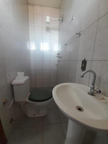 里贝朗普雷托Quarto para temporada的白色的浴室设有卫生间和水槽。