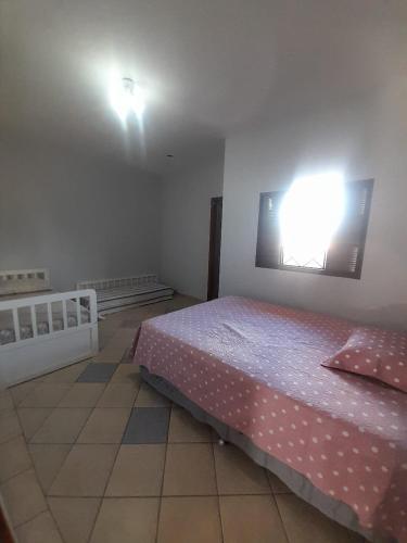 里贝朗普雷托Quarto para temporada的卧室配有一张床,墙上有灯