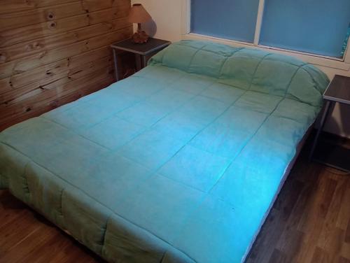 圣卡洛斯-德巴里洛切CABAÑA CASA DE PIEDRA的一张位于带绿床罩的房间的床铺
