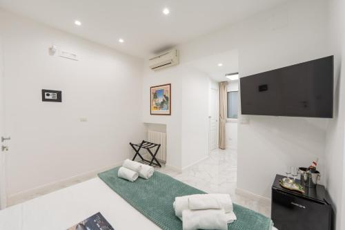 那不勒斯Maison Morghen的一间配备有电视及2条白色毛巾的白色起居室