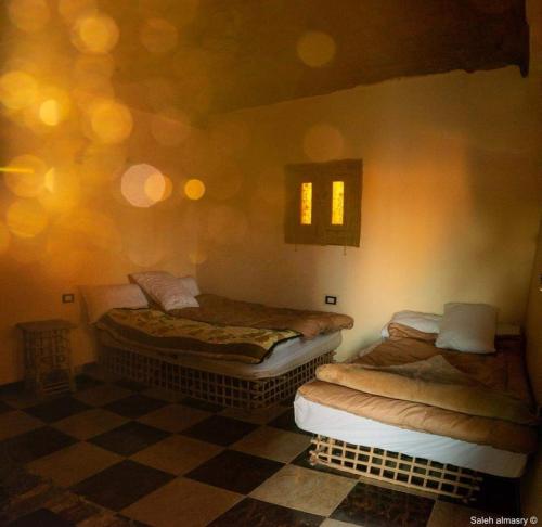 锡瓦غزاله كامب的双床间位于带 ⁇ 形地板的客房内