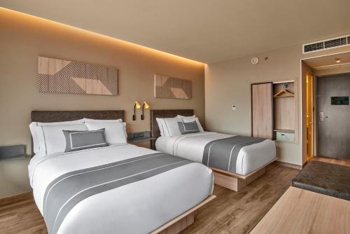 圣路易斯波托西City Express Plus by Marriott San Luis Potosi的一间酒店客房,设有两张床和走廊